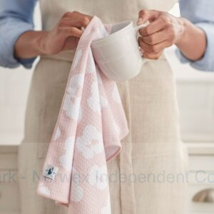 Woman drying a mug with a pink Norwex Tea Towel